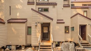A multi-story residential building with a central entrance, numbered 34, and a visible staircase leading to the entrance. - Family Condo in Carnelian Woods (Carnelian Bay)