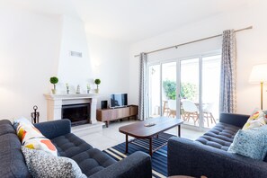 A modern living room with a fireplace, a television, and a sofa set. - CoolHouses Algarve Lagos | Casa Evasion (Lagos)
