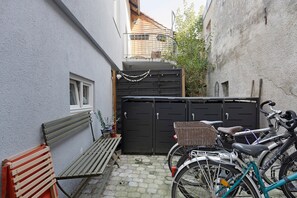 Un callejón estrecho con un banco, una bicicleta y una reja.
