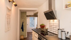 Eine moderne Küche mit schwarzem Arbeitsplatz, Edelstahlgeräten und einer Spritzschutzwand im Ziegeldesign.