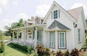 A two-story house with a porch, multiple windows, and a well-maintained lawn. - Sakarin Valley Resort & Restaurant (Kanchanaburi)