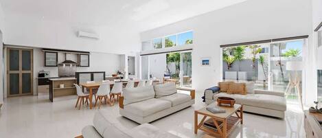 A spacious living area with a sofa, dining table, and kitchen area.