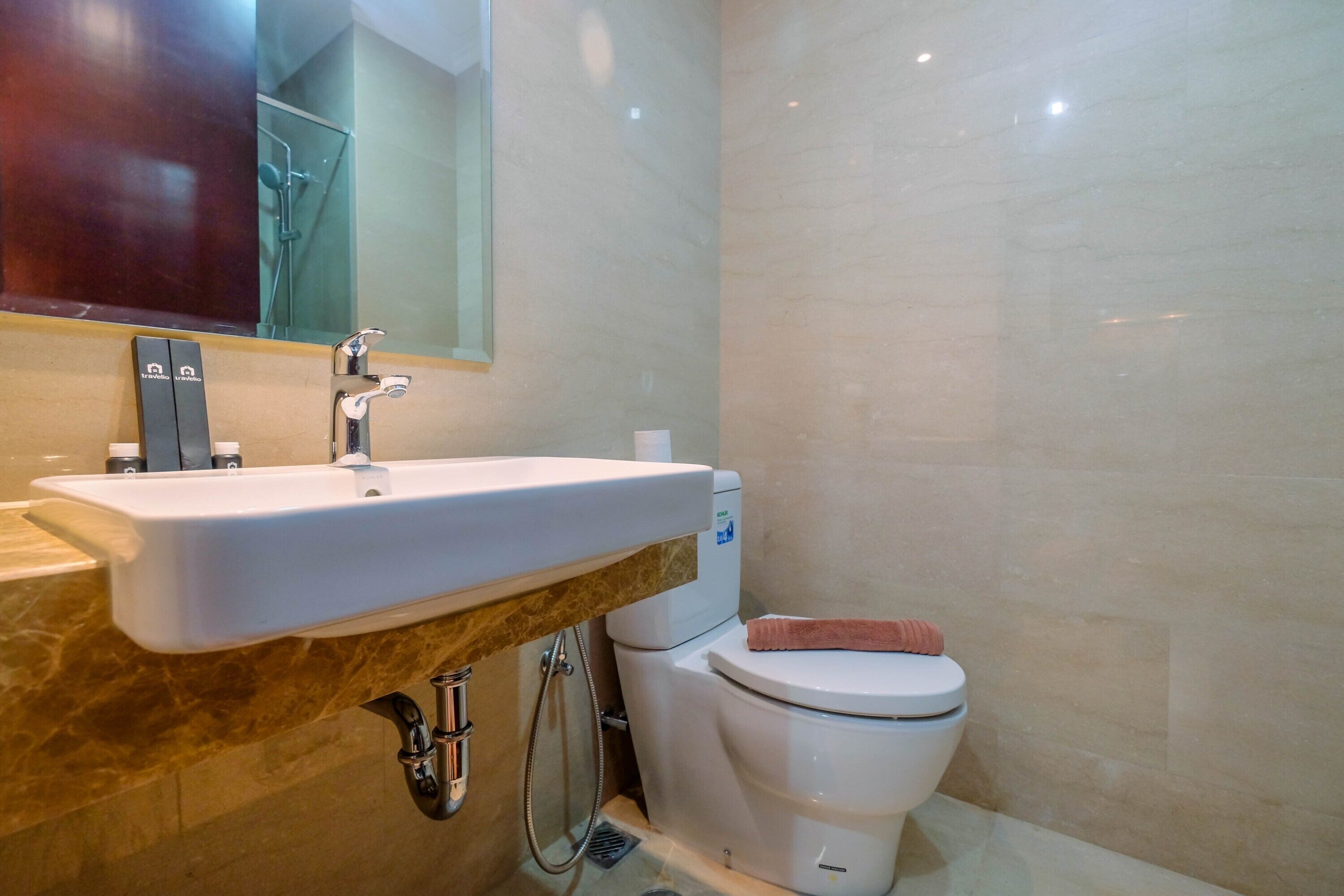 A bathroom with a white sink, a mirror, a toilet, and a shower.