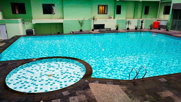 Piscina con borde alicatado y una sección circular con un diseño diferente.