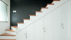 Una escalera con peldaños de madera que conduce a armarios blancos con manijas plateadas.