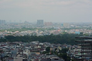 A cityscape with dense residential buildings, a mix of high-rise and low-rise structures, and a large green area in the foreground.