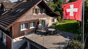A house with a sloped roof, a balcony with outdoor furniture, and a Swiss flag. - Hauswurz by Interhome (Gwatt (Thun))