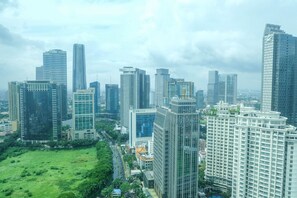 Un paisaje urbano con modernos edificios de gran altura, un parque central y una combinación de estructuras comerciales y residenciales.