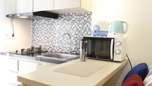 A modern kitchen with a microwave, kettle, and gas stove.