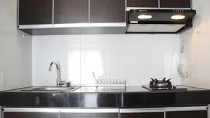 A modern kitchen with stainless steel appliances, a sink, and a gas stove. - Comfortable & Gorgeous 2BR at Gateway Pasteur Apartment (Cimahi)