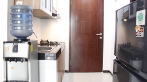 Una cocina con dispensador de agua, estufa y refrigerador.