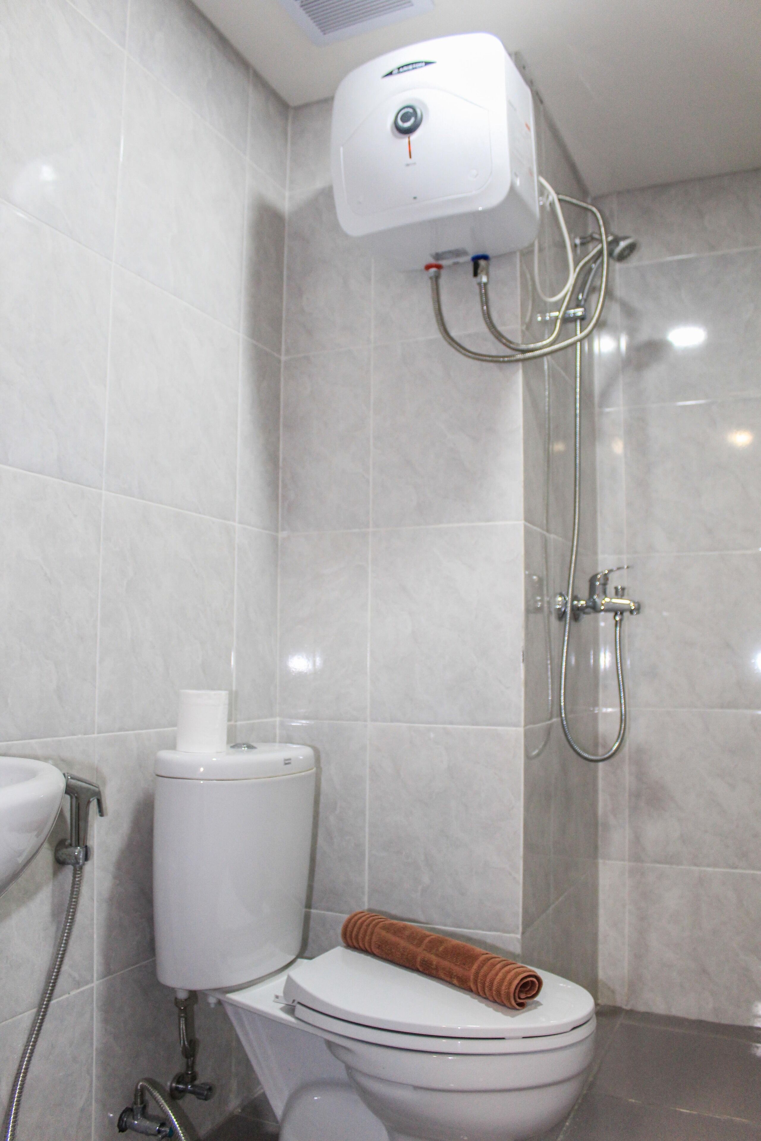 A bathroom with a toilet, a bidet, and a shower.