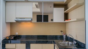Eine moderne Küche mit Einbauherd, Spüle und Mikrowelle. Es gibt eine Holz Arbeitsplatte und Schränke.