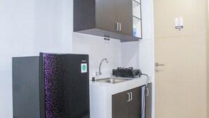 Uma cozinha compacta equipada com geladeira, pia e fogão.