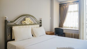 A hotel room with a bed, a desk, and a chair. - Comfortable Studio Apartment at Ayodhya Residences (Tangerang)
