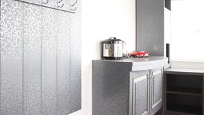 A modern kitchen with a patterned backsplash, a coffee maker, and a red appliance on the counter. - Spacious & Trendy Studio at Jarrdin Cihampelas Apartment (Bandung)