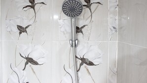A shower with a floral tile design. - Spacious & Trendy Studio at Jarrdin Cihampelas Apartment (Bandung)