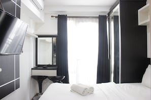 Relax in a serene space with a comfortable bed, flat-screen TV, and large mirror.