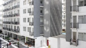 Un edificio residencial de varios pisos con balcones, un patio interior y un diseño arquitectónico moderno.