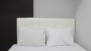 A bed with white bedding and two white pillows.