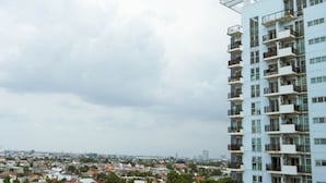 Un edificio alto con varios balcones y vistas a un paisaje urbano.
