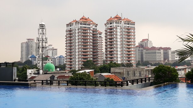 Un complejo residencial con múltiples edificios de apartamentos, una estructura en forma de cúpula verde y una zona de piscina.