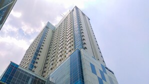 Een hoog gebouw met meerdere verdiepingen, met een combinatie van glazen en betonnen gevels.
