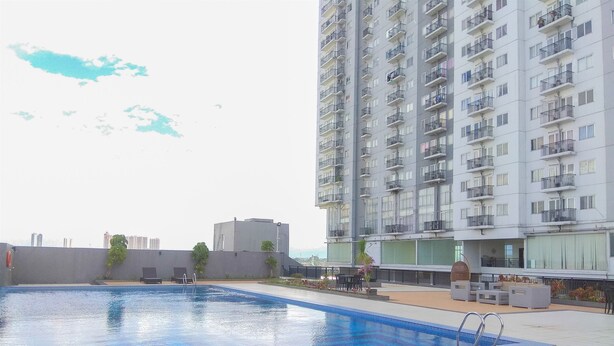 Una piscina en la azotea con vistas a un rascacielos al fondo.