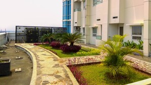 A rooftop garden with potted plants and a pathway. - Enjoy 1BR Apartment at Atlanta Residence (Depok)