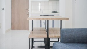 A modern kitchen with white cabinets, a wooden countertop, and a built-in stove. - Comfy and Stylish 2BR Emerald Bintaro Apartment (South Tangerang)