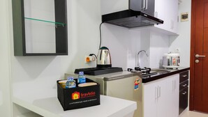 Une cuisine moderne avec des armoires blanches, un plan de travail noir, une machine à café et une boîte étiquetée « Travelio ».