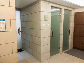 Eine Toilette mit Schild für Damen und Herren, einer Handstange und einer Tür mit Griff.