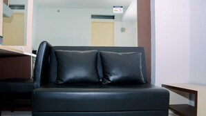 A black leather sofa with two cushions in a hotel room. - Compact and Cozy 2BR Kalibata City Apartment (Jakarta)
