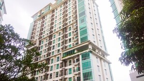 A multi-story building with a modern architectural design, featuring a grid of windows and balconies.