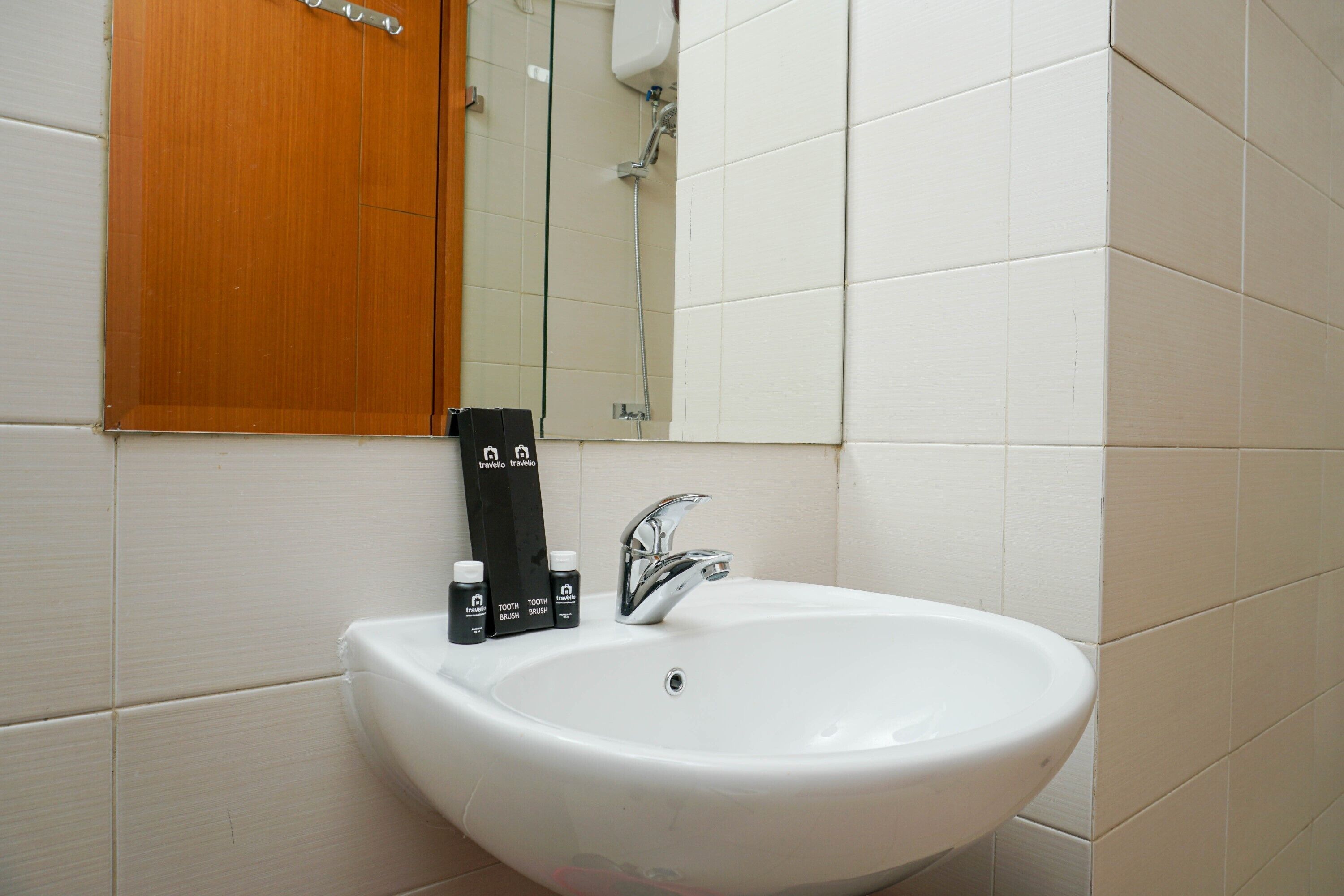 A bathroom with a white sink, a mirror, and a wooden door.