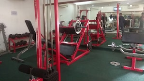 A gym with red equipment, a clock on the wall, and a mirror reflecting the space. - Wonderful and Cozy Studio at Green Palace Apartment (Jakarta)
