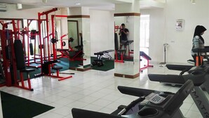 Un gimnasio con equipo de ejercicio, un espejo y una cinta de correr.