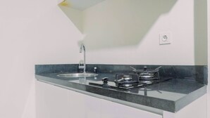 Una cocina con un lavaplatos doble, estufa a gas y un grifo moderno.