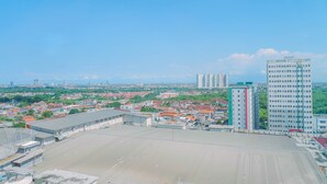 Amplia terraza al aire libre con vistas a un paisaje urbano, que incluye varios edificios y un cielo despejado.