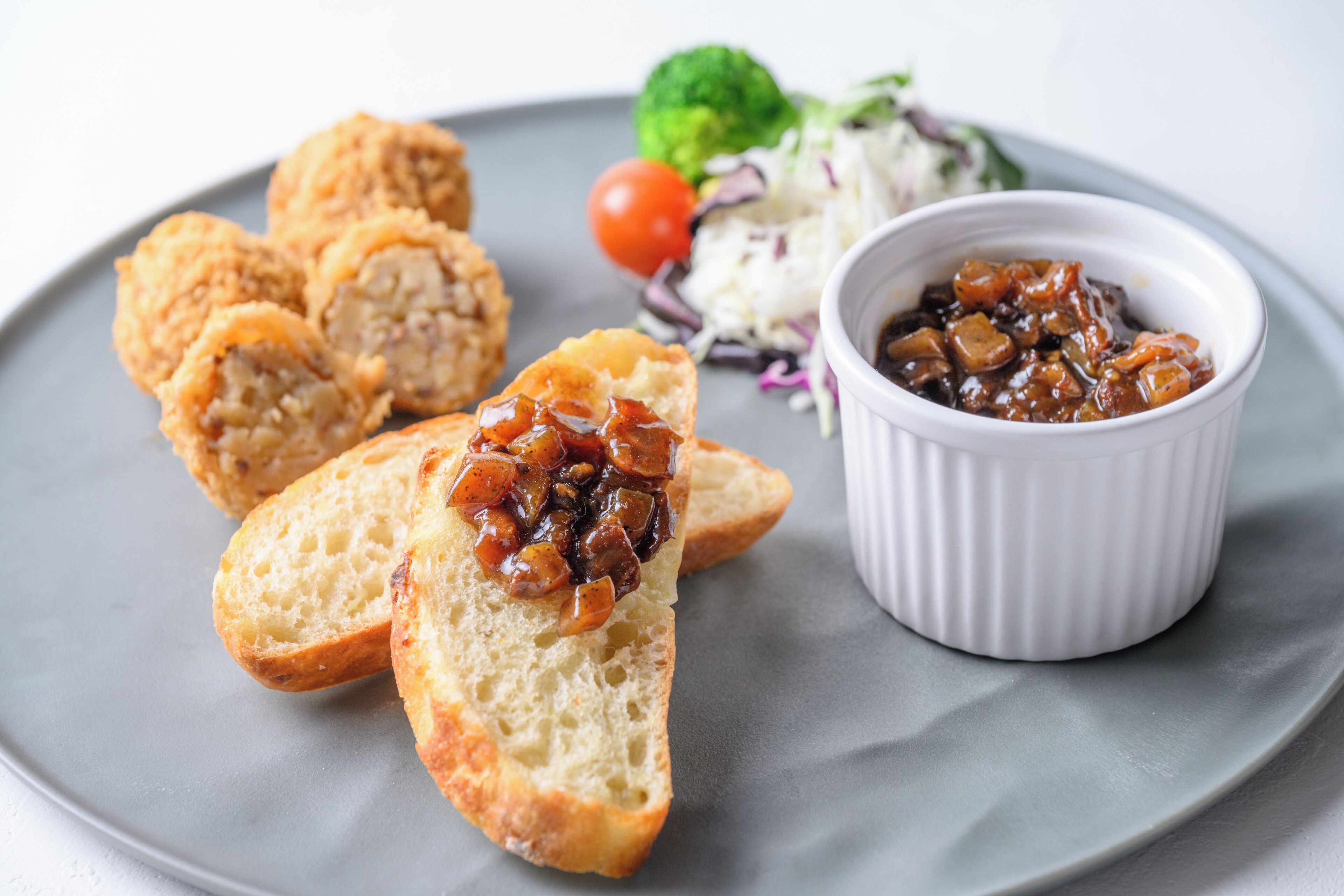 A plate with bread, a small bowl of sauce, and a side salad.