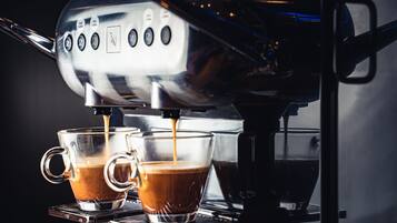 A coffee machine dispensing espresso into two clear cups.