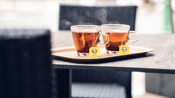 Dos tazas de té sobre una bandeja con etiquetas, colocadas sobre una mesa.