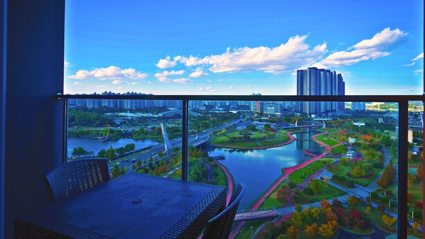 A balcony with a view of a cityscape, including a river, bridges, and high-rise buildings. - K-Hills The Terrace (Paju)