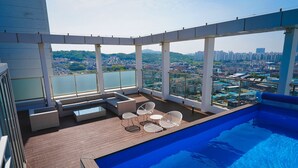 A rooftop pool area with a view of a cityscape, including buildings and greenery. - K-Hills The Terrace (Paju)