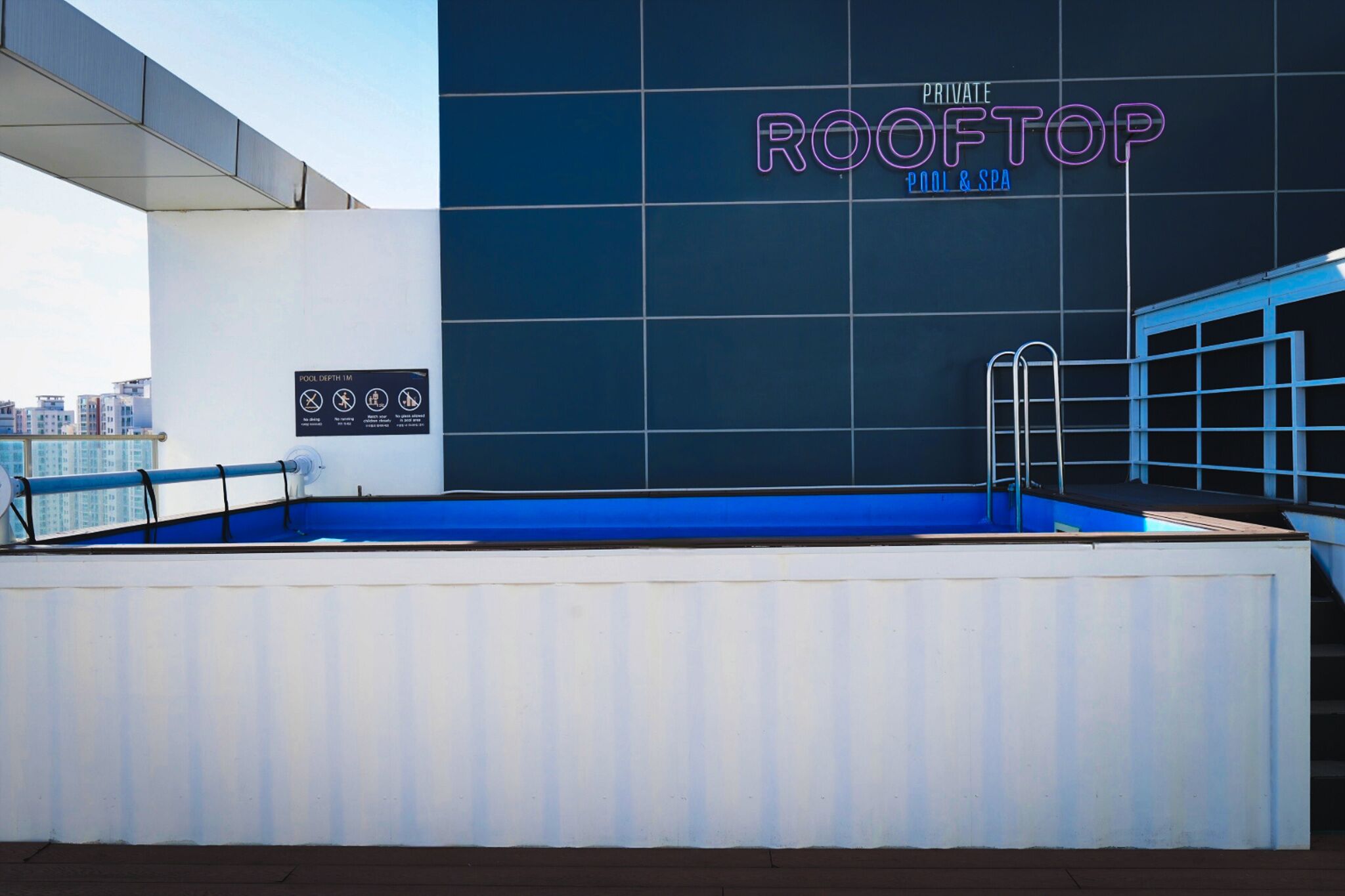 A rooftop pool area with a sign reading "ROOFTOP POOL & SPA".