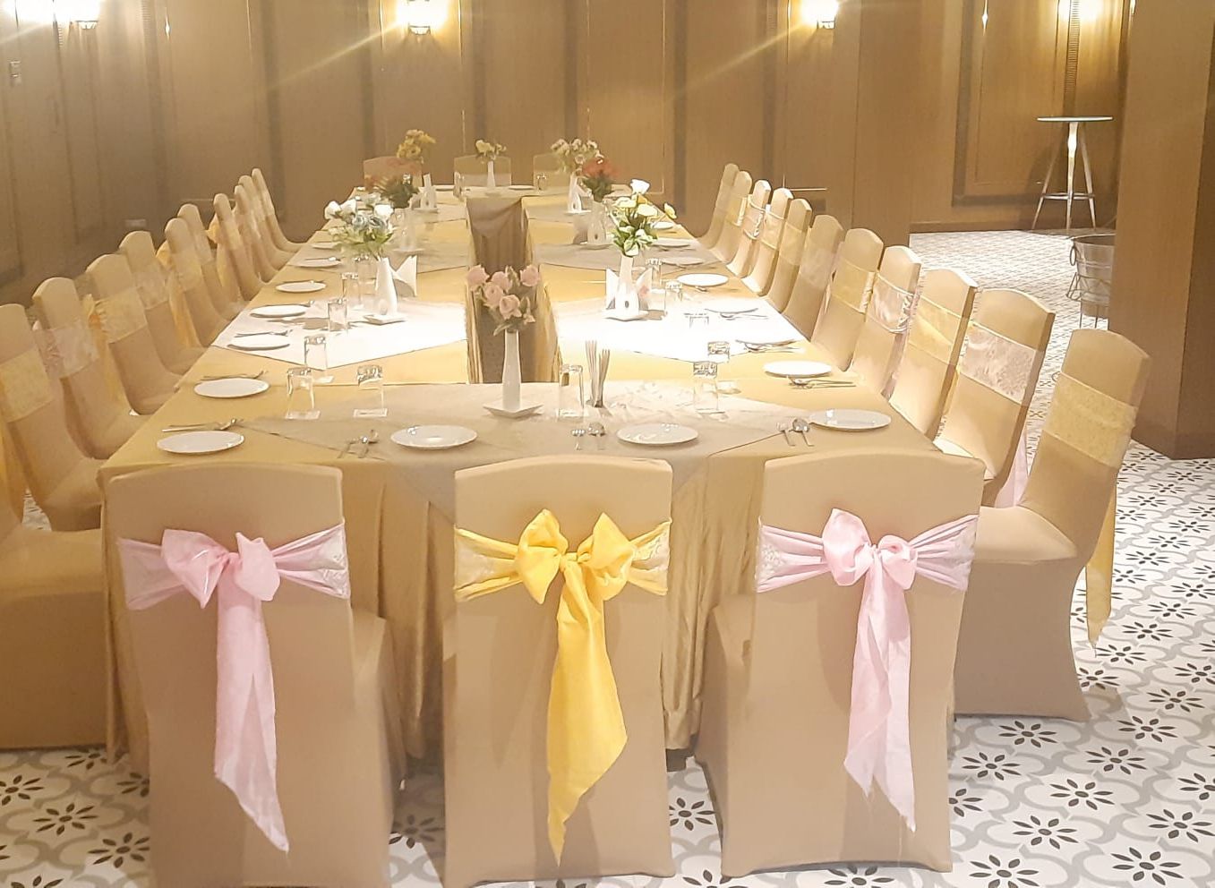 Una sala de conferències amb una taula llarga preparada per a una reunió, envoltada de cadires decorades amb cintes.