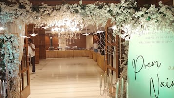 A wedding reception venue with floral decorations, a reception table, and a sign welcoming guests.