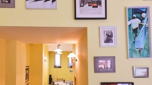 Een hal met een eetgedeelte, met een tafel en stoelen, en een reeks ingelijste foto's aan de wanden.