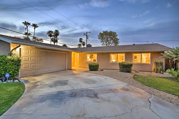 A residential house with a garage, a driveway, and a well-maintained lawn.