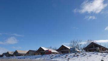 Una fila di chalet con paesaggio innevato e cielo azzurro.